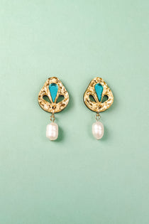 A pair of handcrafted gold-toned Basic Drop Earrings with turquoise accents and dangling white pearls, displayed on a light green background.